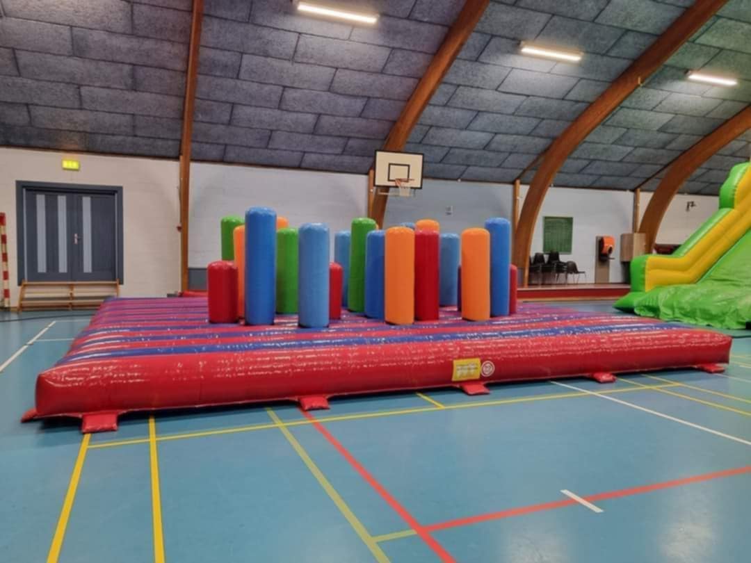 Eight shirts arranged on table in black, olive, grey, blue, white, red, mustard, and green.