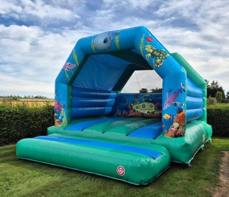 Eight shirts arranged on table in black, olive, grey, blue, white, red, mustard, and green.